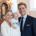 Familie med barn i kirke ved dåb eller navngivning med festlige indslag.
