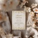 Elegant fest invitation til bryllup med blomster og gyldne detaljer.