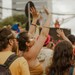 Glade gæster danser og nyder musikken til en livlig sommerfest i festlig stemning.