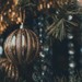 Guld julekugle i gran som dekorativ inspiration til tekst i julekort.
