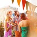 Venner samles til sommerfest med farverig pynt, kolde drikke og hyggeligt samvær udendørs.
